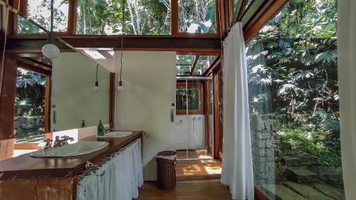 a bathroom with two sinks and a large window at Casa com piscina e vista para o mar em Ilhabela in Ilhabela