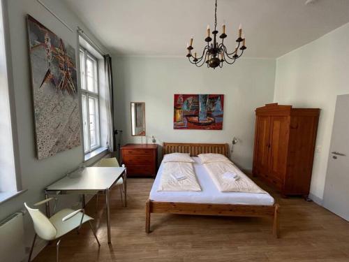 a bedroom with a bed and a table and a chandelier at Ferienwohnung - Schweriner Altstadt - FeWo 5 in Schwerin