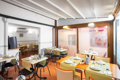 a restaurant with tables and chairs and a tv at Hotel Piazza Di Spagna in Rome