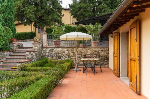 a patio with a table and an umbrella at Agriturismo Vecchio Borgo Di Inalbi in Impruneta