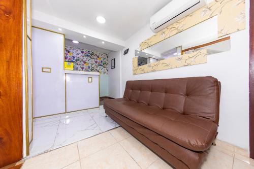 a living room with a brown couch in a room at Hotel Ayenda Palo Alto in Medellín