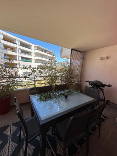 einen Tisch und Stühle in einem Zimmer mit Balkon in der Unterkunft F3 - Standing, idéalement situé in Ajaccio