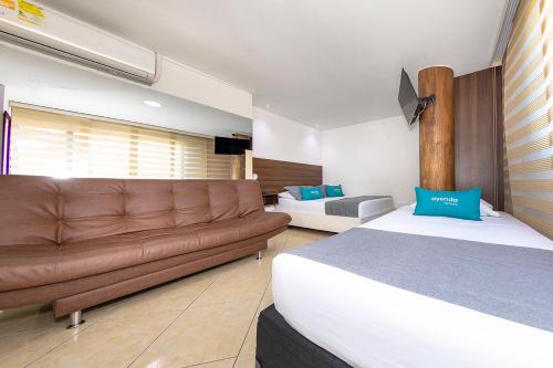 a room with two beds and a couch in it at Hotel Ayenda Palo Alto in Medellín