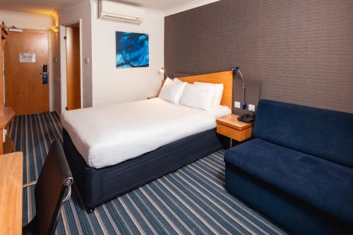 ein Hotelzimmer mit einem Bett und einem Sofa in der Unterkunft Holiday Inn Express Birmingham - Snow Hill, an IHG Hotel in Birmingham