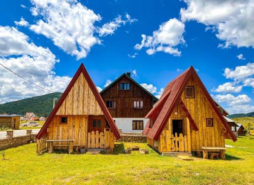 un paio di edifici in legno in un campo di Cottage Bumblebee a Žabljak