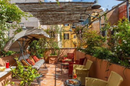 an outdoor patio with chairs and an umbrella at Hotel Piazza Di Spagna in Rome