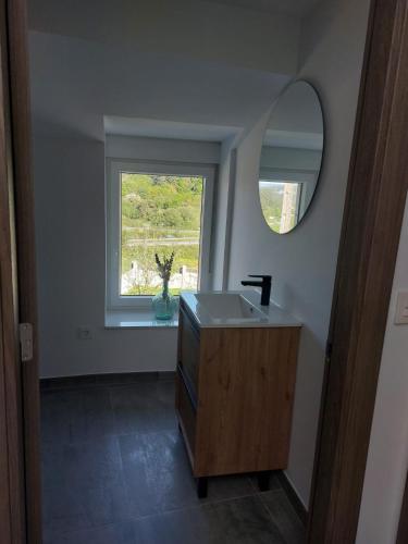 a bathroom with a sink and a mirror and a window at O Recuncho de Domingos in Brion de Abajo