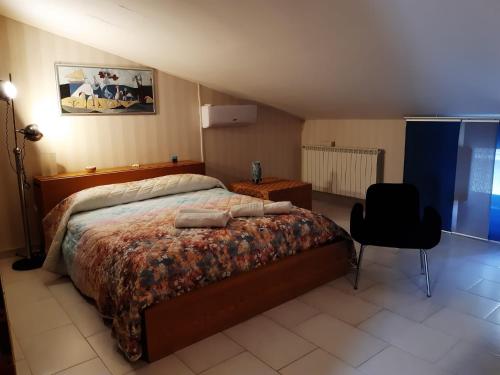 a bedroom with a large bed and a chair at Basilicò in Caltagirone