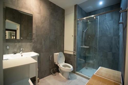 a bathroom with a shower and a toilet and a sink at Chiang Mai luxury condo hidden in the city in Chiang Mai