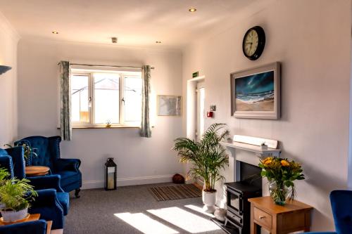 a living room with a fireplace and a clock on the wall at The Shelbourne in Llandudno