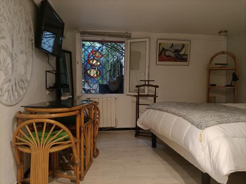1 dormitorio con cama, escritorio y ventana en Cielito Lindo, en Montpellier