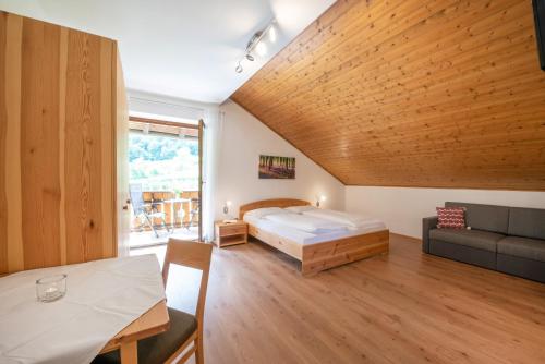 1 dormitorio con 1 cama y 1 sofá en una habitación en Eich-hof, en Caldaro