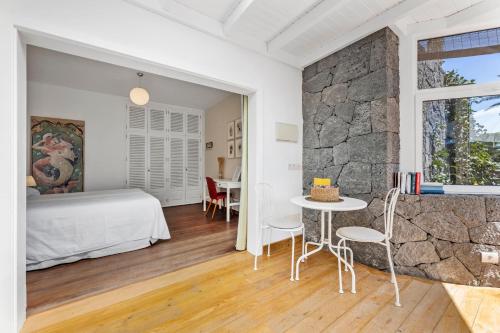 a bedroom with a bed and a table and chairs at Apartamento Lanzarote Art Suite 3 in San Bartolomé
