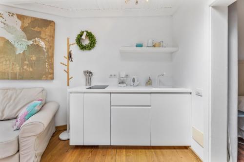 a white kitchen with a sink and a couch at Apartamento Lanzarote Art Suite 3 in San Bartolomé
