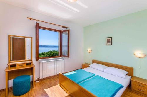 a bedroom with a bed and a desk and a window at One-Bedroom Apartment Crikvenica 6 in Dramalj