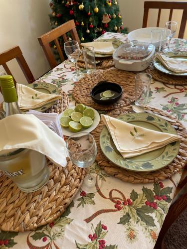 a christmas table with plates and glasses and a christmas tree at Casa Sra Oti in Puerto Montt