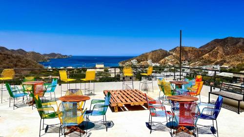 a group of chairs and a table with a view of the ocean at Samarian Hostel in Taganga