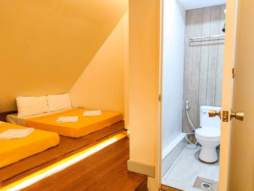 a small room with two beds and a toilet at Baguio Camella Big Brother House in Baguio