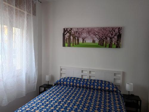 a bedroom with a bed and a painting on the wall at Bilocale Kenya in Caorle
