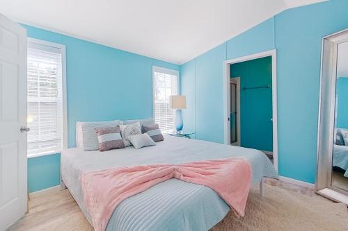 um quarto com paredes azuis e uma cama grande em The Blue Bayou em Naples
