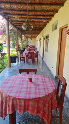 a table with a red plaid table cloth on a patio at Hospedaje El Cascabel in Sunampe