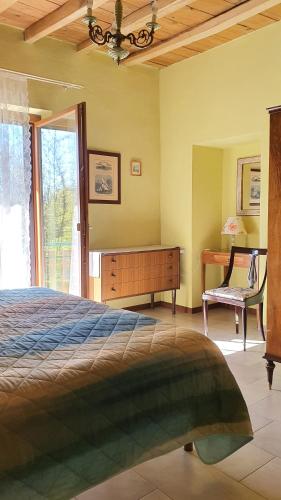 a bedroom with a bed and a desk and a chair at Il Casolare del Medio Olona in Fagnano Olona