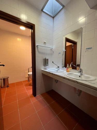 łazienka z 2 umywalkami i lustrem w obiekcie Casa da Cabração - Circuito Aldeias de Portugal w mieście Ponte de Lima