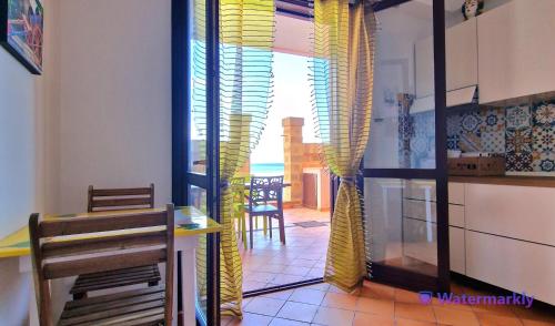 a kitchen and dining room with a view of the ocean at La Casa sulla Spiaggia in Marzamemi