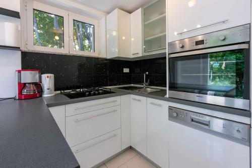 a white kitchen with white cabinets and a sink at Crikvenica Apartment 24 in Dramalj