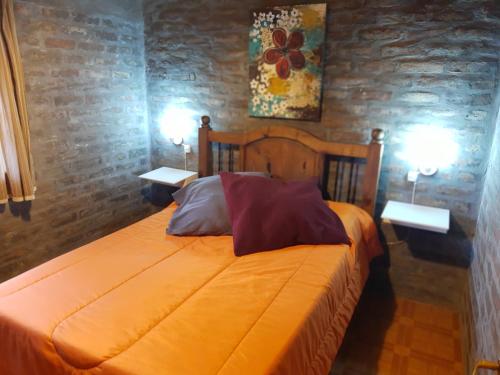 een slaapkamer met een bed met 2 kussens erop bij Lo de Quebu Cabaña en la Montaña in Potrerillos
