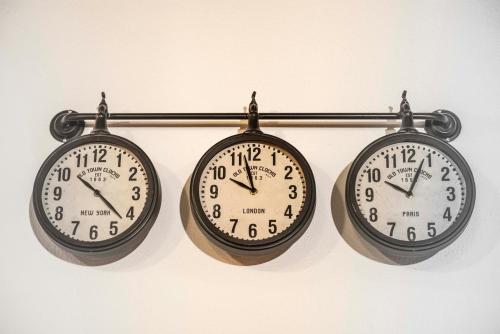 three clocks are hanging on a wall at Khris Home Apartments - Trastevere Crisogono in Rome