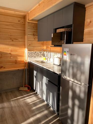 a kitchen with a refrigerator and a sink at Cabañas La Matanza in Matanzas