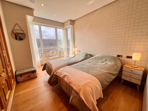 een slaapkamer met een bed en een groot raam bij Apartamento nuevo en el centro de Ourense 1 in Ourense