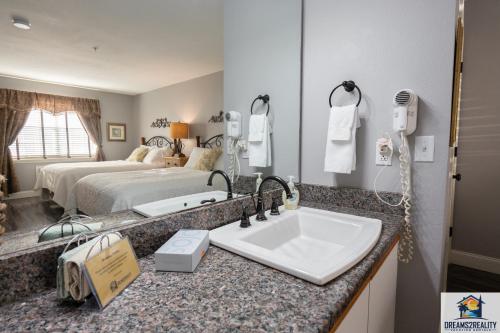 a bathroom with a sink and a bed at 2BR Walk-In Condo - Near the 76 Strip - Pool - FREE TICKETS INCLUDED - CLA-8 in Branson