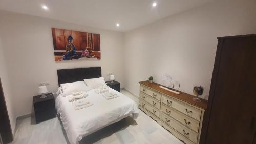 1 dormitorio con cama y tocador de madera en LyriosHomes Apartamentos Los Tréboles, en Málaga