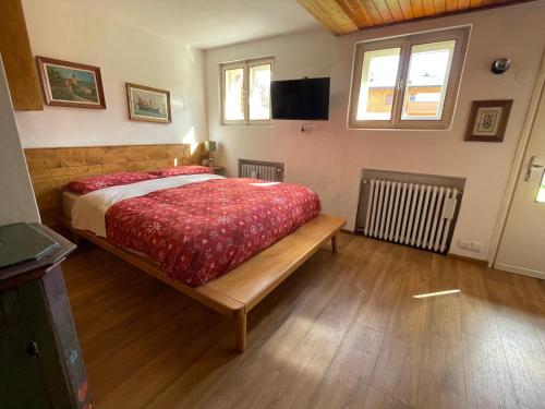 a bedroom with a bed and a television in it at La Roncolina in Cortina dʼAmpezzo