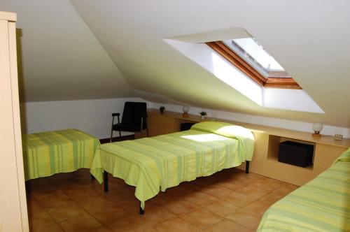 a attic room with two beds and a skylight at Residence Milena in Milano Marittima