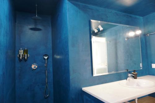 a blue bathroom with a sink and a mirror at Goldra Cozy Villa with private pool in Valados