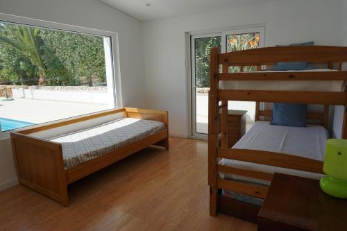 a bedroom with two bunk beds and a large window at Goldra Cozy Villa with private pool in Valados