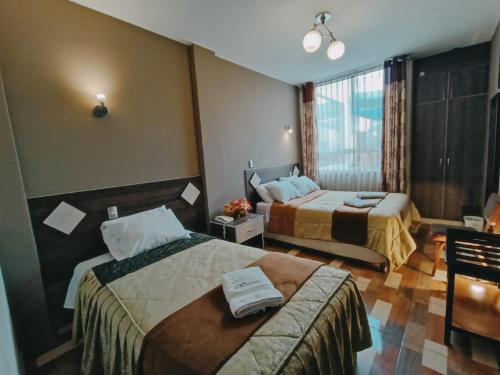 Habitación de hotel con 2 camas y ventana en Hotel Real Salaverry *** Inkahoteles, en Arequipa