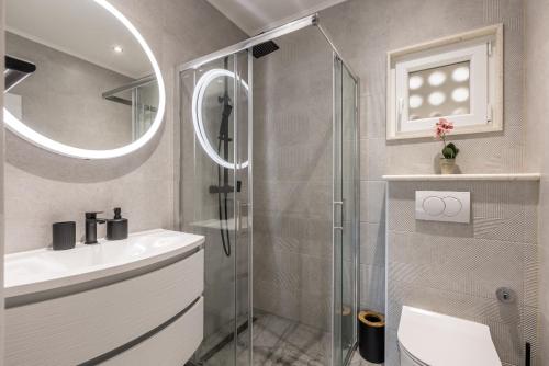 a bathroom with a shower and a toilet and a sink at Apartments Petra in Bol