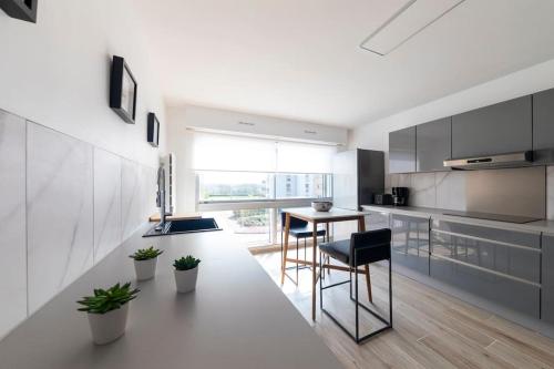 une cuisine avec une table et des chaises dans une pièce dans l'établissement BORD DE PLAGE.Magnifique Appartement face Mer., à Calais
