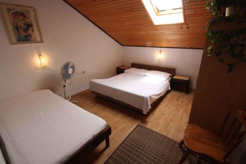 a small bedroom with two beds and a fan at Apartment in Dramalj 5752 in Dramalj