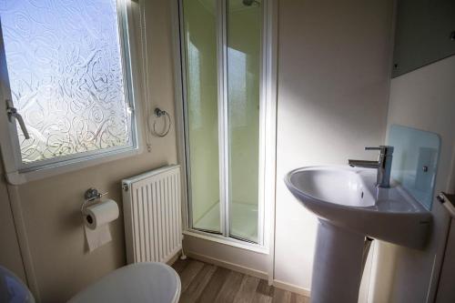 a bathroom with a sink and a glass shower at 6 Berth Caravan For Hire In Hunstanton At Manor Park Holiday Park Ref 23004a in Hunstanton