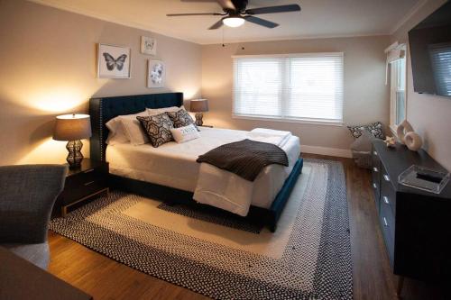 Un dormitorio con una cama y un ventilador de techo. en The Midtown Gem, en Tulsa
