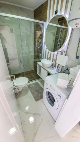 a bathroom with a washing machine and a sink at House De Luxe in Bihać