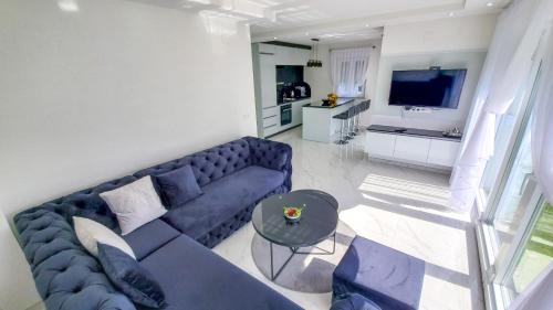 een woonkamer met een blauwe bank en een tafel bij House De Luxe in Bihać