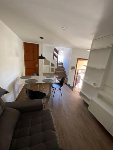 a living room with a couch and a table at Casa triplex com cobertura a 5 minutos da praia in Arraial do Cabo