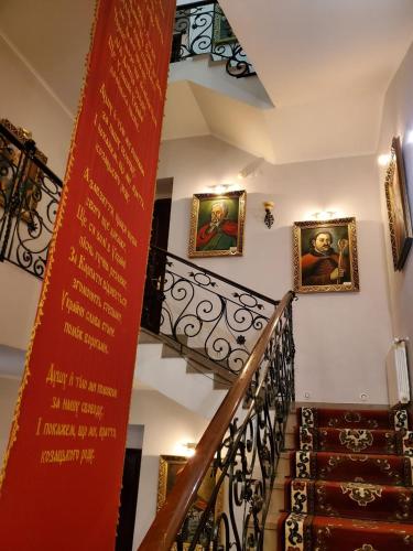 a stairway with paintings on the walls of a building at Hetman Hotel in Kamianets-Podilskyi