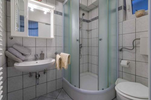 a bathroom with a shower and a sink and a toilet at One-Bedroom Apartment in Crikvenica XVII in Dramalj